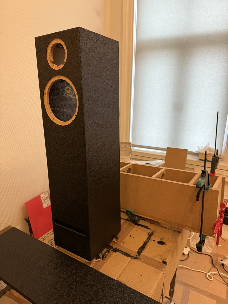 Bare prototype cabinet on the workbench, driver cutouts visible