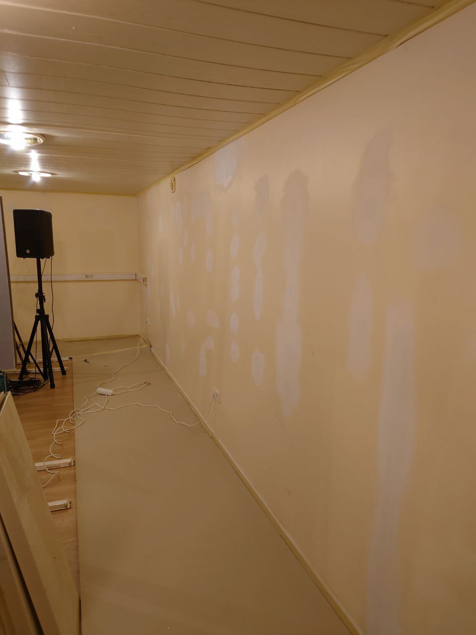 The room with raw plaster patches still visible on the long wall, pre-painting
